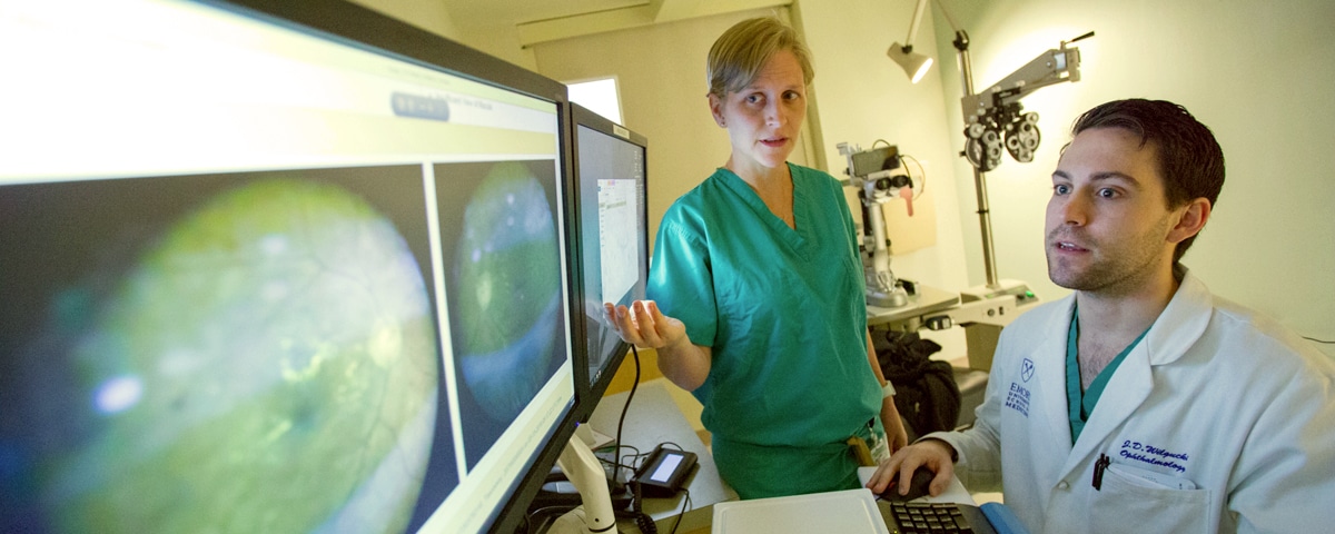 Eye Doctor reviewing scan of eye on monitor