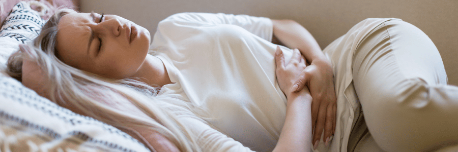 a woman lying in bed suffering UTI